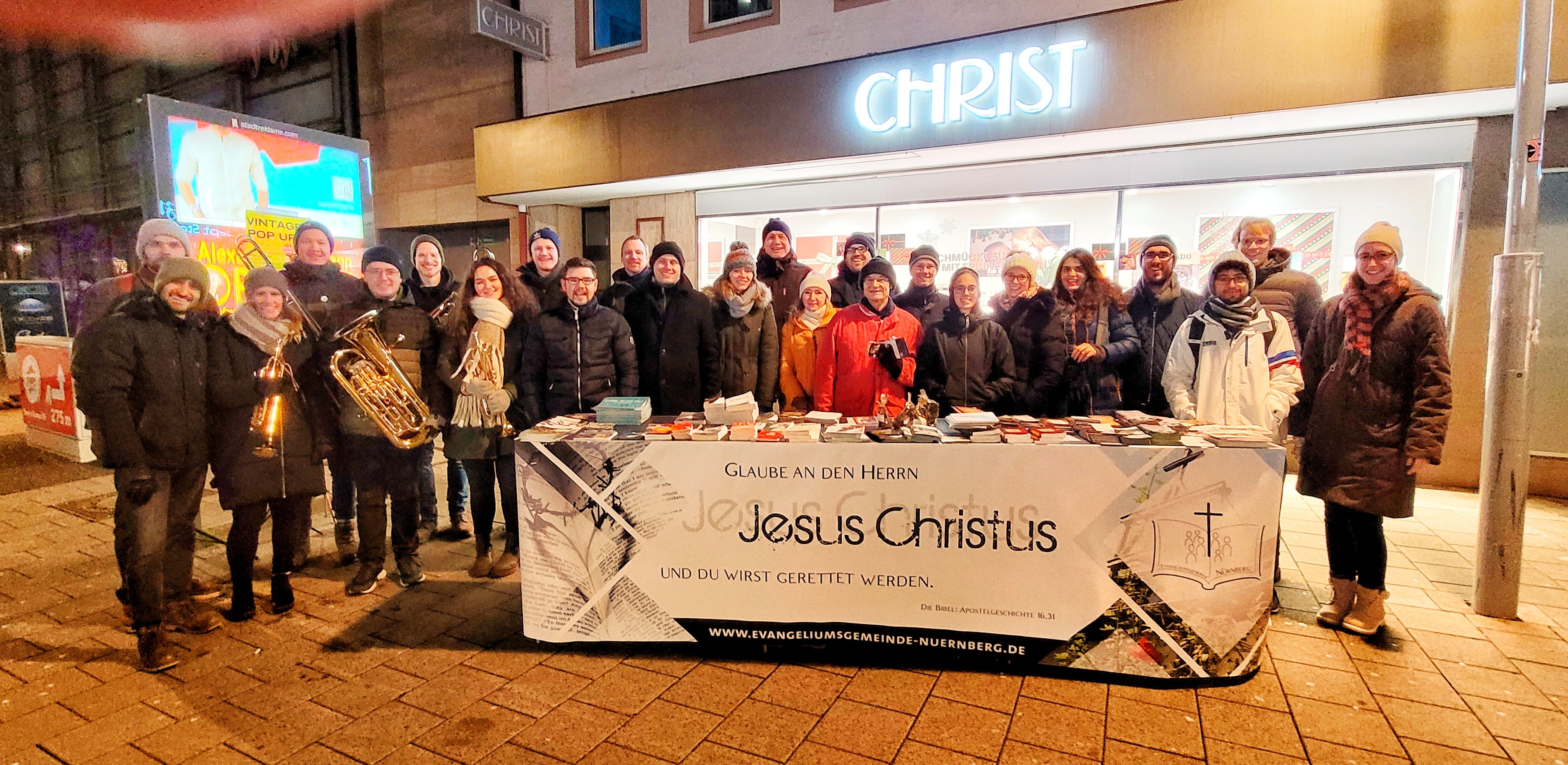 Straßeneinsatz in der Stadt, Gemeindebesucher stehen hinter dem Büchertisch am Abend